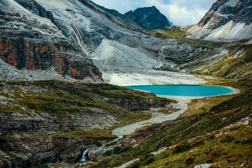 四川稻城亚丁雪山脚下湖泊倒影清晰可见雪峰高耸入云