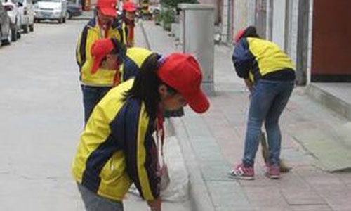 一位清洁工阿姨在清晨打扫街道