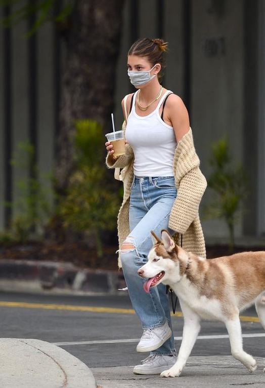 现代朋友互相扶持走在街头背影图