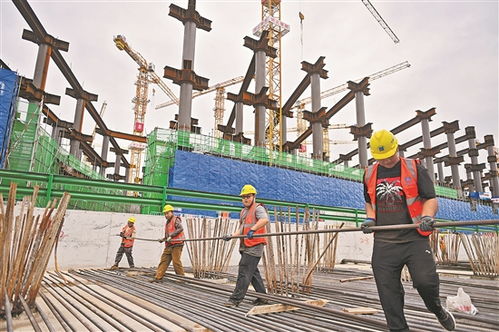 建筑工人在阳光下搬运钢筋