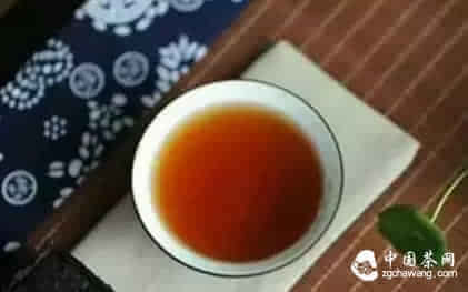一杯浓茶与白色药片对比图