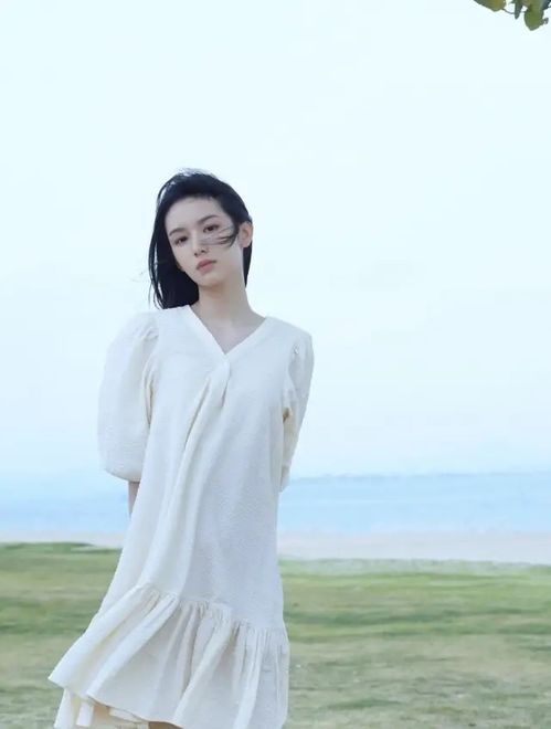 女生穿着白色连衣裙在海边拍照