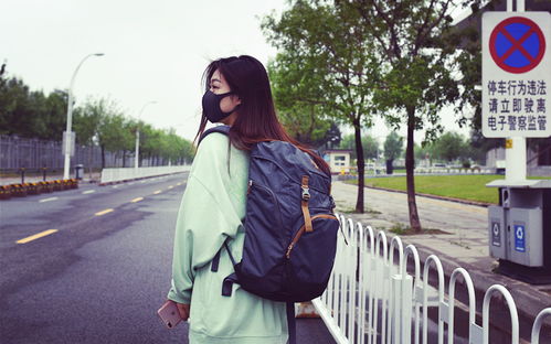 一位年轻人背着背包走在晨曦中的小路上