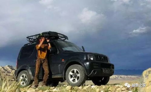 男子坐在车边看着远方的城市夜景