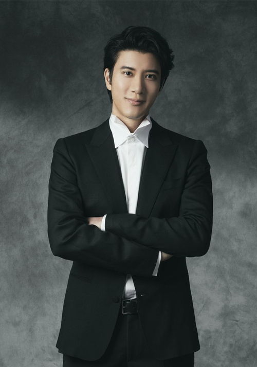 王力宏在后台与工作人员沟通,神情认真