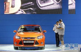 一位年轻夫妇在汽车展会上咨询价格