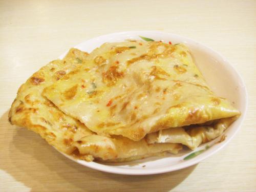 李伯在街头忙碌地制作鸡蛋饼