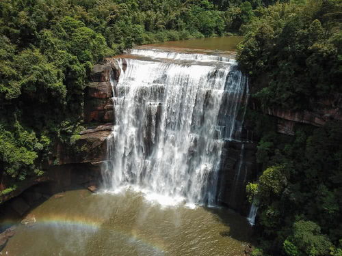 游客在贵州赤水丹霞大瀑布景区附近拍摄山体崩塌后的车辆