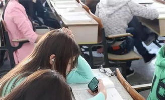 大学生在操场上坐着玩手机