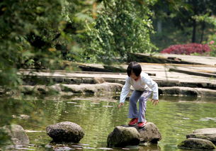 小孩在池塘边玩耍滑倒瞬间抓拍图