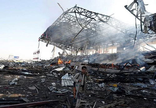 也门民众站在机场废墟前