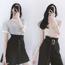 一位年长女性穿着优雅简约风服装站在镜子前