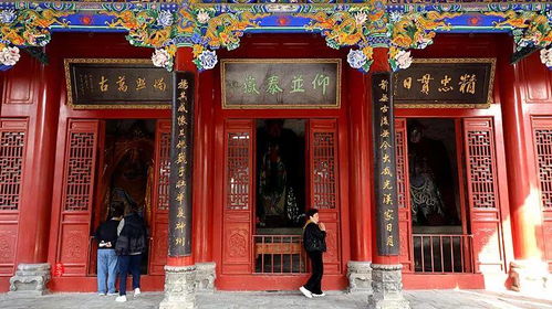 一位年轻女子站在寺庙大殿前双手合十闭眼祈祷