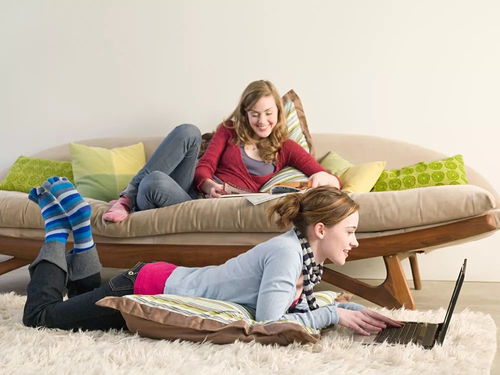 母女俩坐在沙发上聊天笑得很开心