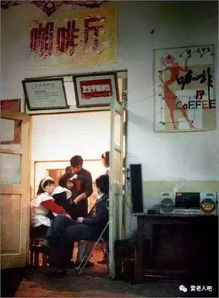 张康乐在咖啡馆里翻看老照片微笑