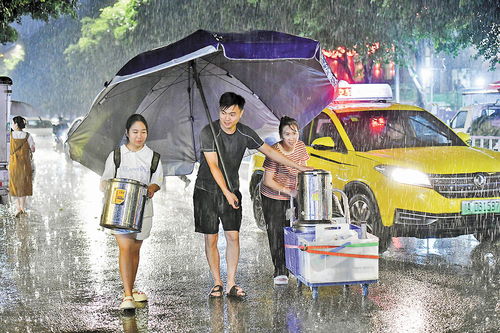 街道上行人撑着伞走在雨中