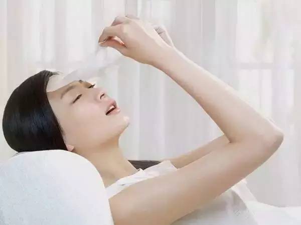 孕妇对着镜子微笑敷面膜