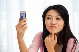 一位女性站在镜子前自拍的侧脸特写