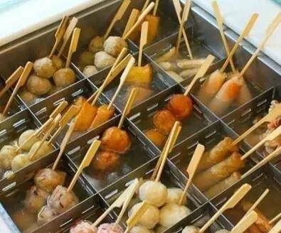 道崽在街头吃着关东煮边看手机