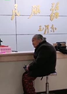 家属抬着老人走进银行大厅的照片