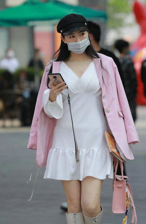 粉色连衣裙与白色外套搭配的女生站在樱花树下