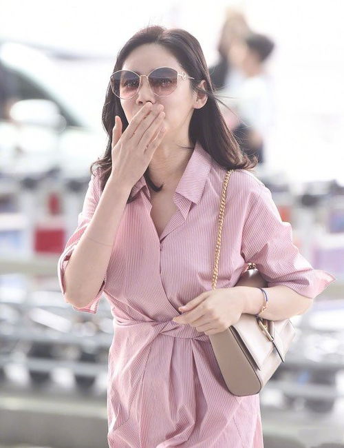 穿着粉色裙子的女孩在阳光下转圈拍照的瞬间