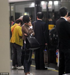 地铁站内市民低头玩手机等待列车进站