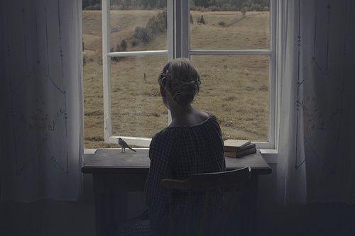 女生坐在窗边画画