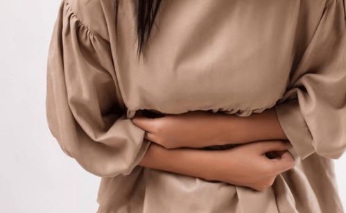一名女性捂着腹部表情痛苦
