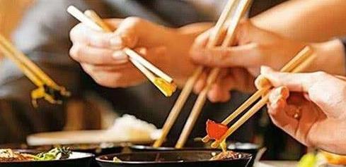 一个人在餐厅中用筷子夹起少量米饭