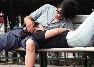 一对情侣在公园长椅上依偎