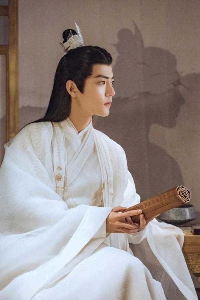 肖战穿着精致刺绣的古装，手持长剑，背景为夜色下的宫殿