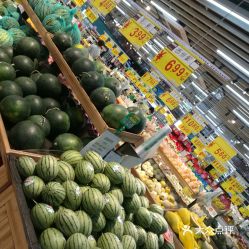 一位女士在超市挑选新鲜水果准备制作清凉饮品