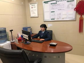 一位年轻人坐在办公桌前认真阅读书籍