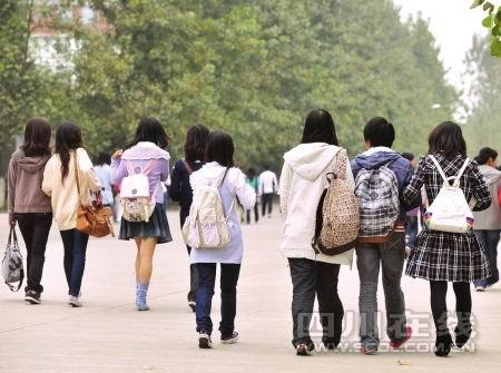 三年级学生背着书包走在学校走廊