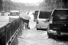 暴雨中车辆行驶在积水道路上