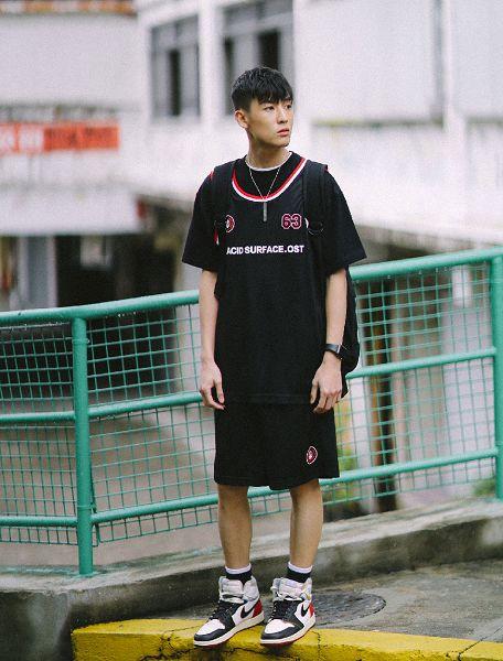 一名高中生穿着球衣站在球场中央