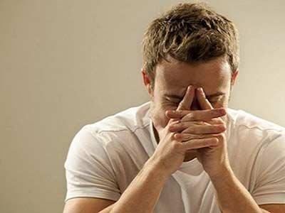 年轻男子捂着胸口躺在床上表情痛苦