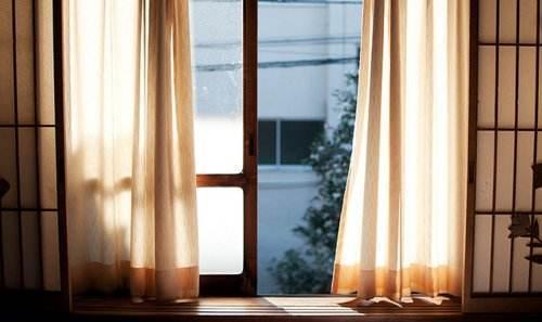 女性早晨拉开窗帘迎接阳光