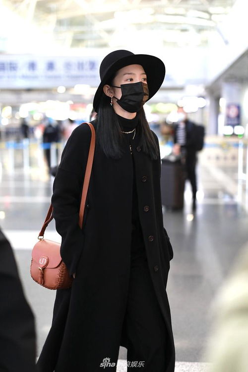 女孩戴着宽檐帽穿着户外穿搭站在草地上