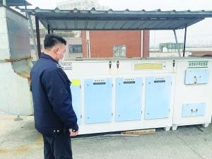 执法人员对企业排污设备进行检查