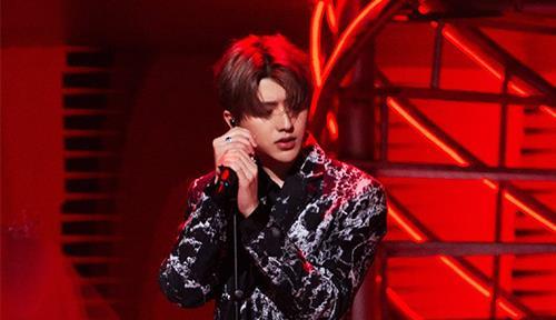 蔡徐坤在舞台上激情演唱的照片
