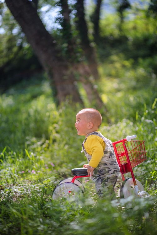 摄影师背着相机走在空旷的山路上