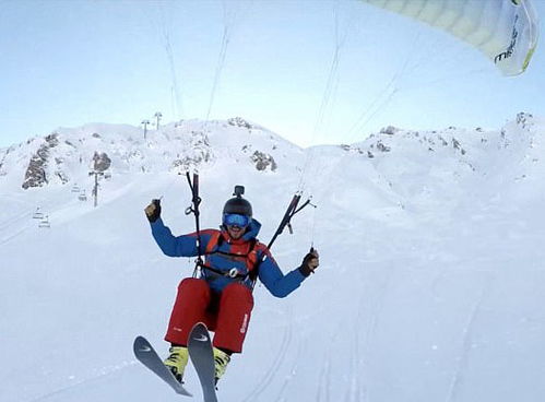 滑翔伞爱好者在高空中俯瞰雪山的画面