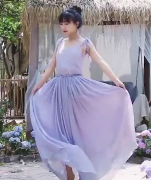 李子柒身穿紫色长裙站在山间