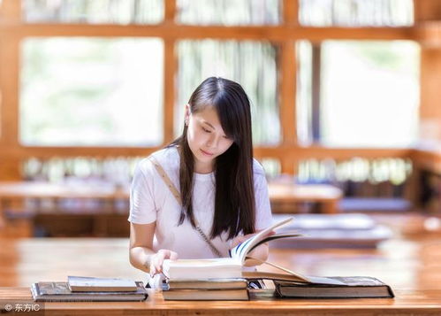 作者手持笔记本坐在窗边写作的照片