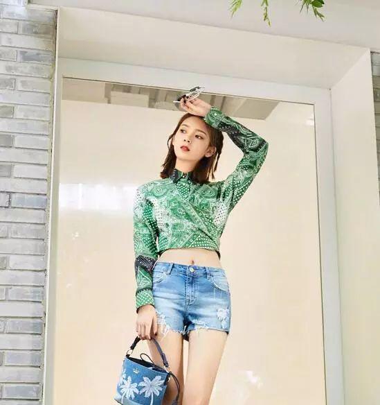 陈瑶身穿墨绿色旗袍手拿折扇