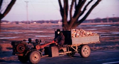 父亲在农田边修理拖拉机