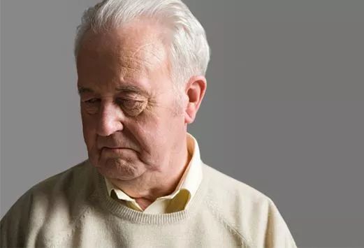 一位年轻人握着老人的手微笑