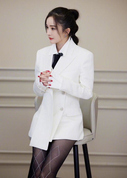 杨幂身穿黑色西装在VOGUE主题墙前拍照